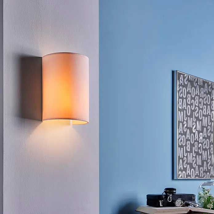 Lindby Wandleuchte Annalisa - weiß / opal, E27 - Zylindrische Stoff-Wandleuchte, die warmes Auf- und Ablicht auf einer strukturierten Wand spendet.