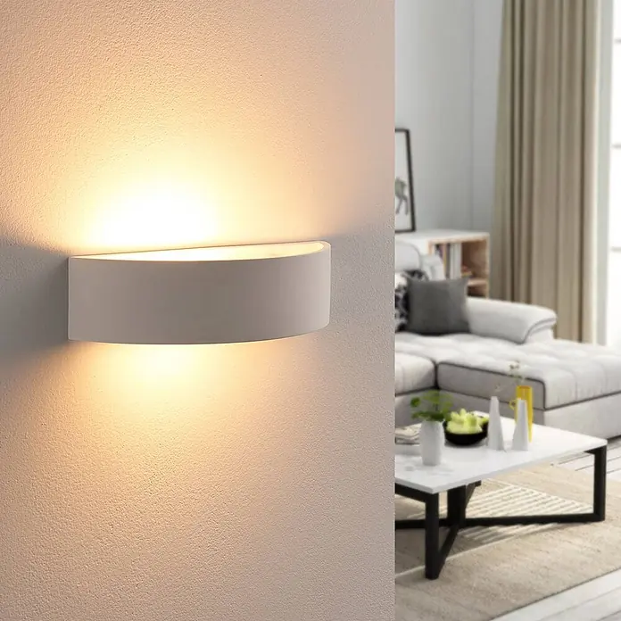 Lindby Wandleuchte Aurel - weiß / opal, E14 - Weiße halbkreisförmige Wandleuchte, die warmes Licht nach oben und unten abgibt, in einem modernen Wohnzimmer.