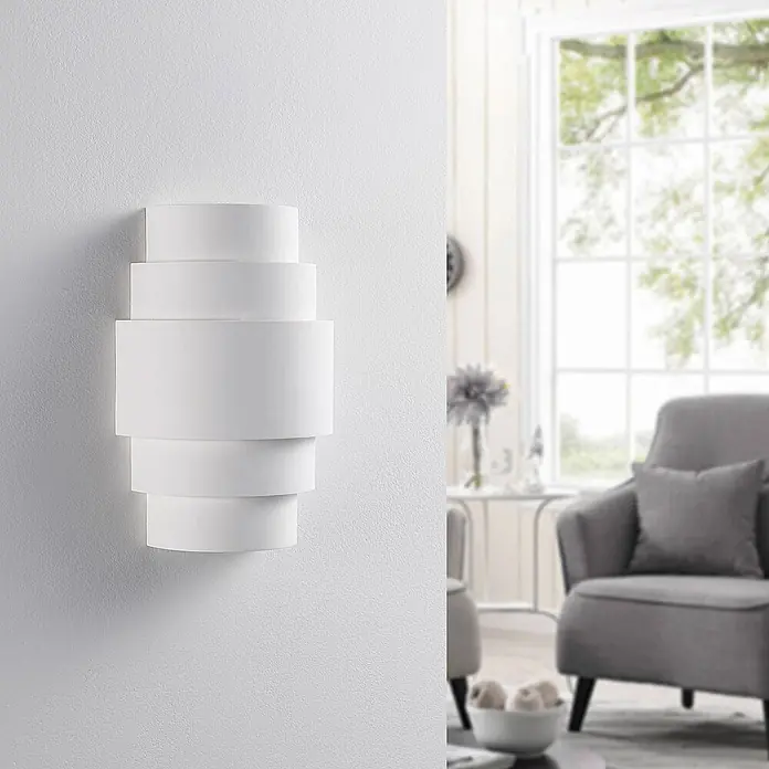 Lindby Wandleuchte Marit - weiß / opal, E14 - Weiße, gestapelte zylindrische Wandleuchte mit modernem geometrischem Design an einer Wand.