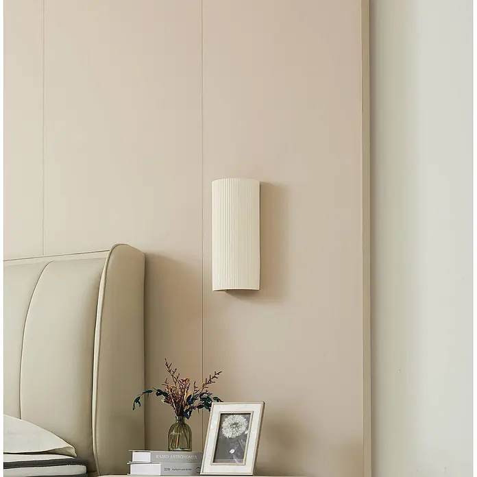 Lindby Wandleuchte Colja - L x B x H: 9,6 x 13,3 x 30,5 cm, creme / amber, creme / amber, GU10 - Creme-farbene, vertikal gerillte Wandleuchte, montiert an einer Schlafzimmerwand über einem Nachttisch.