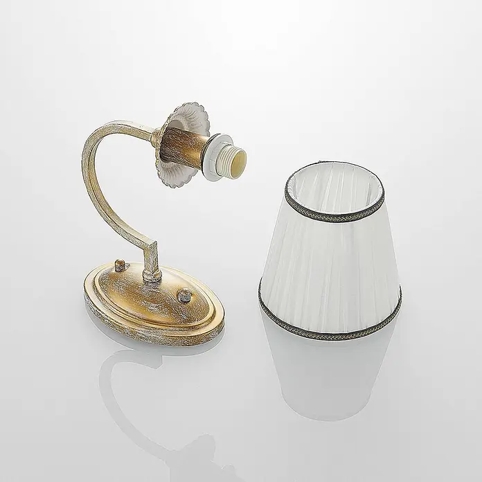 Lindby Wandleuchte Lumiel - bronze / altmessing, creme / amber, E14 - Antikes goldfarbenes Wandleuchten-Gestell mit abgenommenem weißen plissierten Lampenschirm mit Zierleiste.