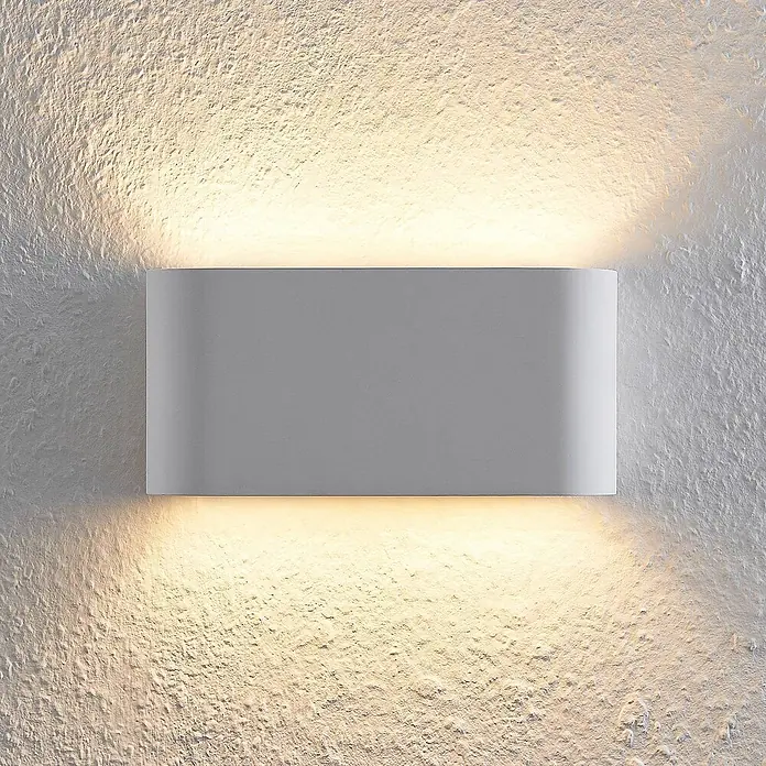 Lindby Wandleuchte Mavora - L x B x H: 7 x 25 x 12 cm, weiß / opal, G9 - Rechteckige graue Wandleuchte, die eine strukturierte Wand nach oben und unten mit warmem Licht beleuchtet.