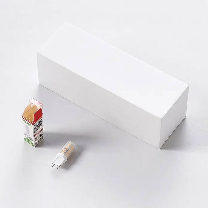 Lindby Wandleuchte Santino - L x B x H: 7,5 x 21,8 x 7,5 cm, weiß / opal, G9 - Weiße rechteckige Verpackungsbox, kleine LED-Birne mit G4-Sockel und Karton.