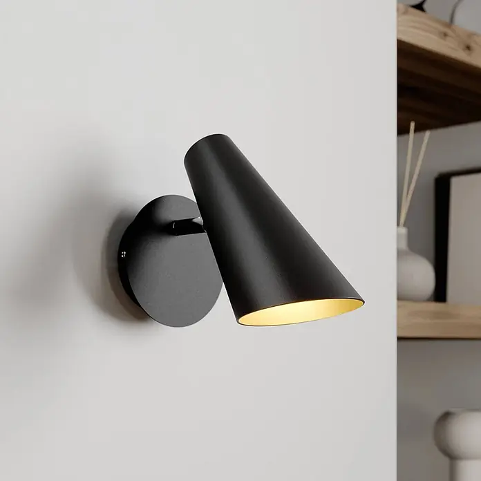 Lucande Wandleuchte Wibke - L x B x H: 17 x 9 x 24 cm, schwarz, schwarz, GU10 - Schwarze Wandleuchte mit konischem Schirm und goldener Innenseite, an einer Wand montiert und beleuchtet.
