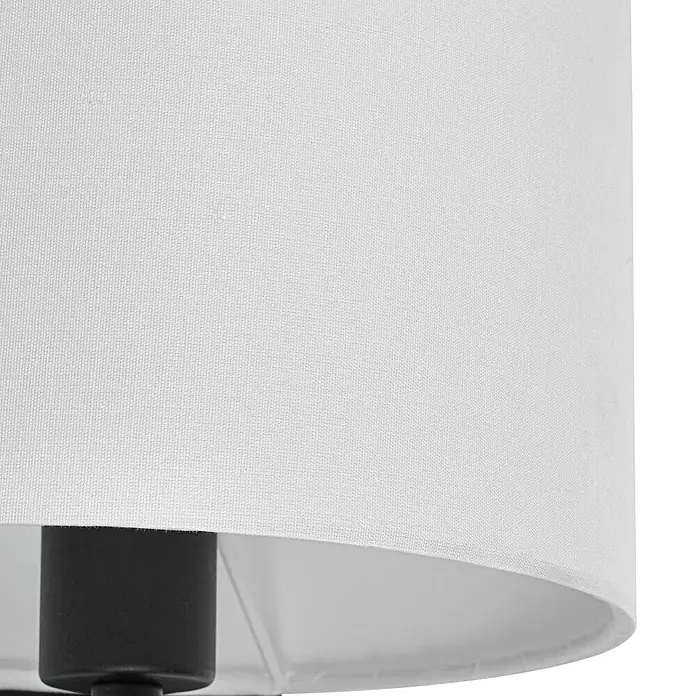 Lindby Wandleuchte Florens - weiß / opal, E14 - Nahaufnahme eines weißen Stoff-Lampenschirms mit sichtbarem schwarzem Lampenfuß darunter.