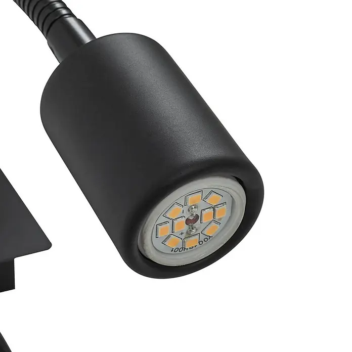 Lindby Wandleuchte Florens - weiß / opal, E14 - Nahaufnahme eines schwarzen Lampenkopfes mit flexiblem Arm und sichtbarer LED-Birne mit mehreren bernsteinfarbenen Chips.