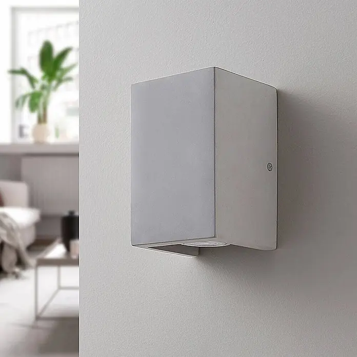 Lindby Wandleuchte Gerda - alu / grau / zink, GU10 - Silbergraue rechteckige Wandleuchte an der Wand, die einen modernen Raum beleuchtet.