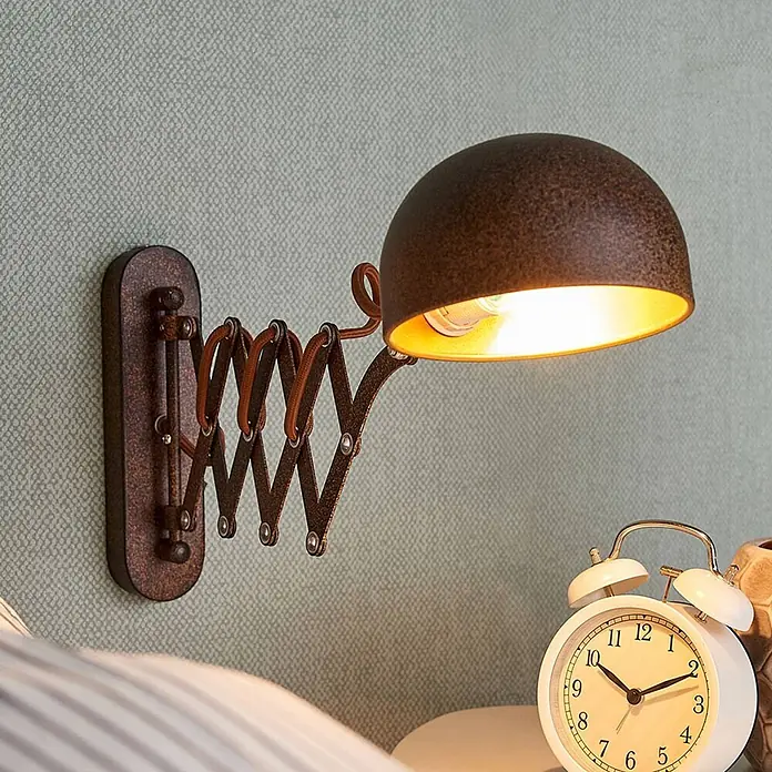 Lindby Wandleuchte Curtis - L x B x H: 57 x 13 x 23 cm, braun / rost, braun / rost, E14 - Rustikale dunkelbraune Metall-Wandlampe mit verstellbarem Scherenarm und beleuchtetem Kuppelschirm, über Nachttisch montiert.
