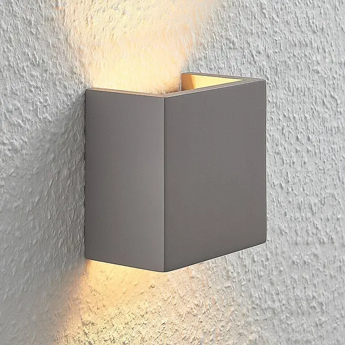 Lindby Wandleuchte Smira - L x B x H: 7,5 x 12,5 x 12,5 cm, alu / grau / zink, G9 - Graue, eckige Wandleuchte, die warmes Licht nach oben und unten auf eine strukturierte Wand strahlt.
