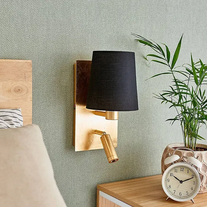 Lindby Wandleuchte Aiden - messing / gold, schwarz, E14 - Goldene Wandleuchte mit schwarzem konischem Schirm und verstellbarer Leselampe, im Schlafzimmer montiert.