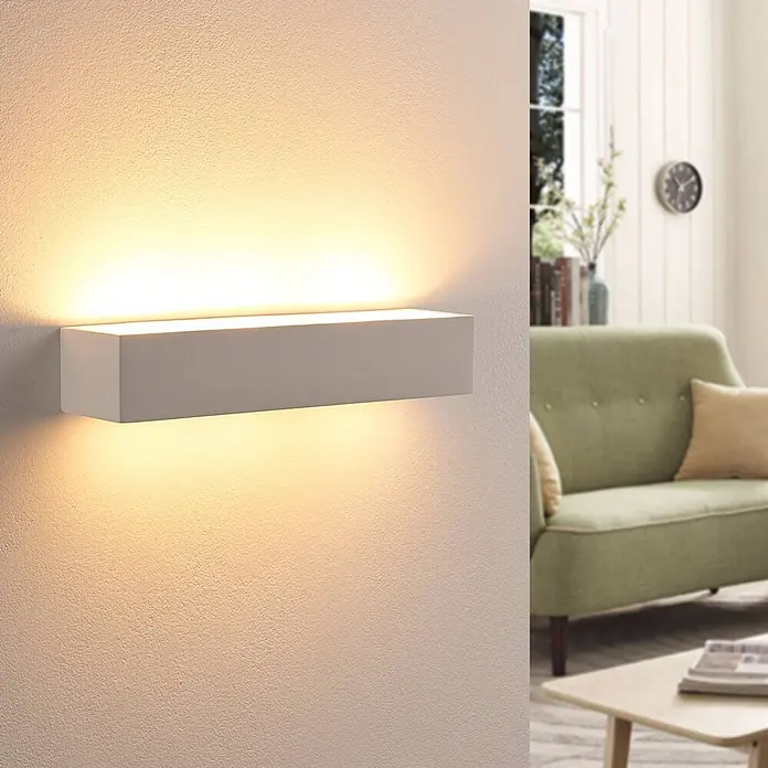 Lindby Wandleuchte Arya - weiß / opal, G9 - Weiße rechteckige Wandleuchte, die warmes Licht nach oben und unten an eine strukturierte Wand abgibt.