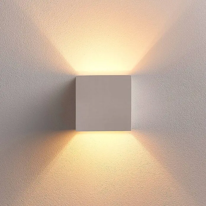 Lindby Wandleuchte Kay - L x B x H: 11,5 x 11,5 x 11,5 cm, weiß / opal, G9 - Weiße quadratische Wandleuchte, die warmes Licht nach oben und unten auf eine strukturierte Wand wirft.