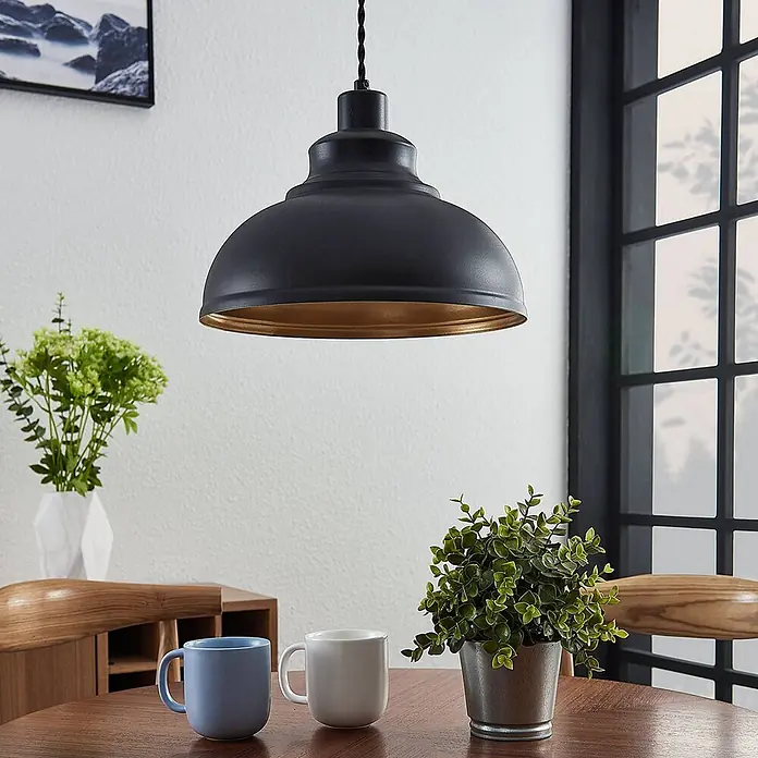 Lindby Pendelleuchte Albertine - L x B x H: 29 x 29 x 19,7 cm, schwarz, Schwarz, gold, E27 - Schwarze Metall-Pendelleuchte mit goldener Innenseite hängt über einem Holztisch.