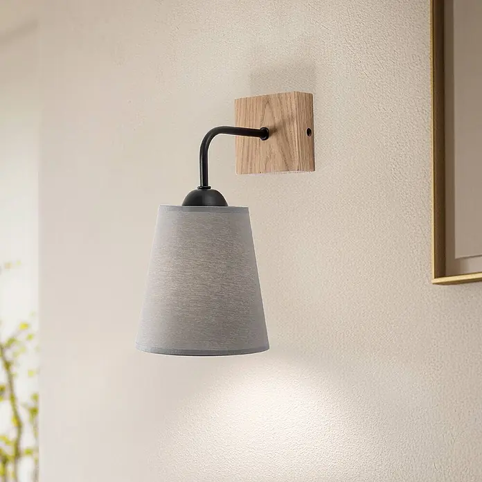 Envostar Wandleuchte Risco - L x B x H: 21 x 15 x 30 cm, Holz hell, alu / grau / zink, E27 - Wandlampe mit hellem Holzsockel, schwarzem Metallarm und grauem Stoff-Kegelschirm, die ein warmes Licht nach unten wirft.