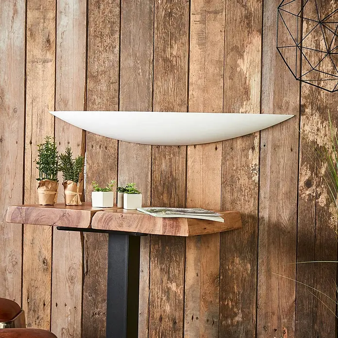 Lindby Wandleuchte Tommi - weiß / opal, E14 - Ein langes, geschwungenes weißes Wandregal, montiert an einer rustikalen Holzwand über einem Konsolentisch mit Baumkante.
