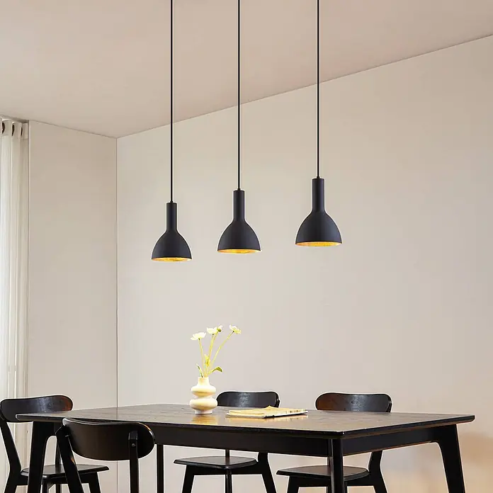 Arcchio Pendelleuchte Cosmina - L x B x H: 100 x 17,5 x 26 cm, schwarz, Schwarz, gold, E27 - Drei schwarze Pendelleuchten mit goldenen Innenseiten über einem Esstisch, die ihre Verwendung in einem Esszimmer zeigen.
