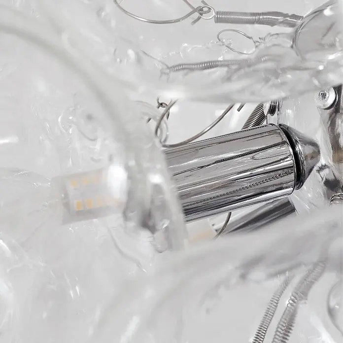 Lucande Pendelleuchte Diborah - L x B x H: 43 x 43 x 40 cm, klar / transparent, transparent, chrom, G9 - Innenansicht einer modernen Leuchte: verchromte Basis, klares Glas, LED-Birne und Metallfedern.