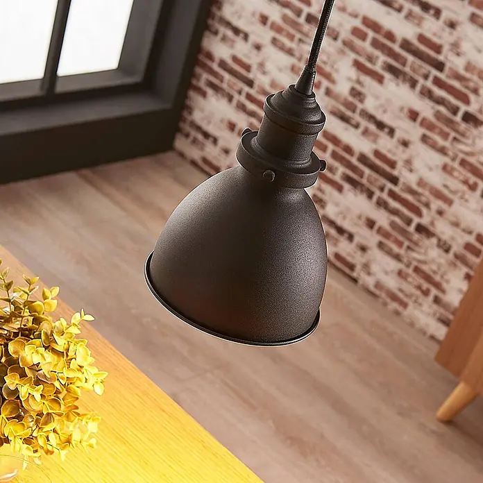 Lindby Pendelleuchte Jasminka - L x B x H: 15,5 x 15,5 x 20 cm, schwarz, Schwarz, gold, E27 - Industrielle Pendelleuchte aus dunklem Metall über einem Holztisch.