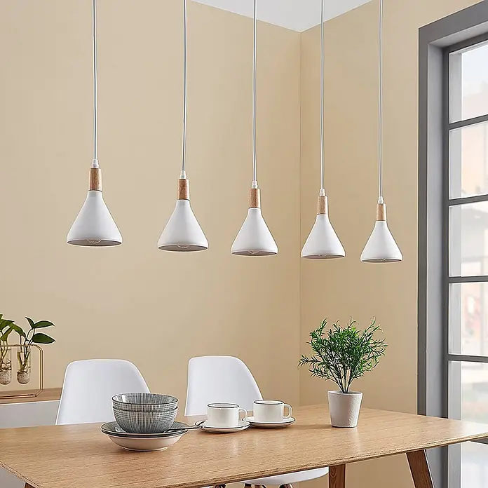 Lindby Pendelleuchte Arina - weiß / opal, weiß, holz hell, E14 - Set aus 5 weißen konischen Pendelleuchten mit Holzdetails über einem Esstisch hängend.