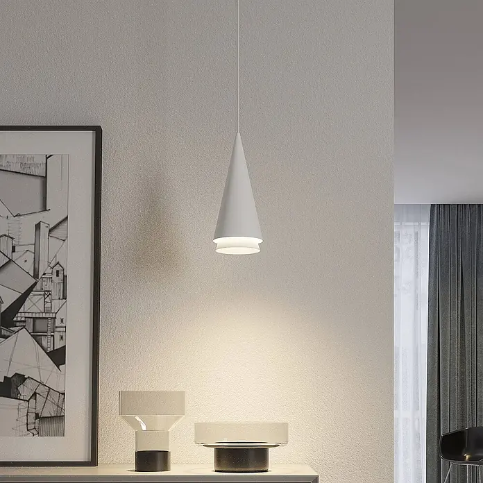 Lucande Pendelleuchte Naoh - weiß / opal, weiß matt, E27 - Weiße, kegelförmige Pendelleuchte, die eine strukturierte Wand und Deko-Objekte darunter beleuchtet.