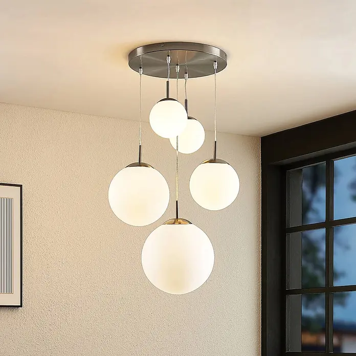 Lindby Pendelleuchte Heleska - weiß / opal, nickel matt, opalweiß, E27 - Moderne Deckenleuchte mit fünf weißen Opalglaskugeln an gebürsteter Metallplatte, in einem Raum.