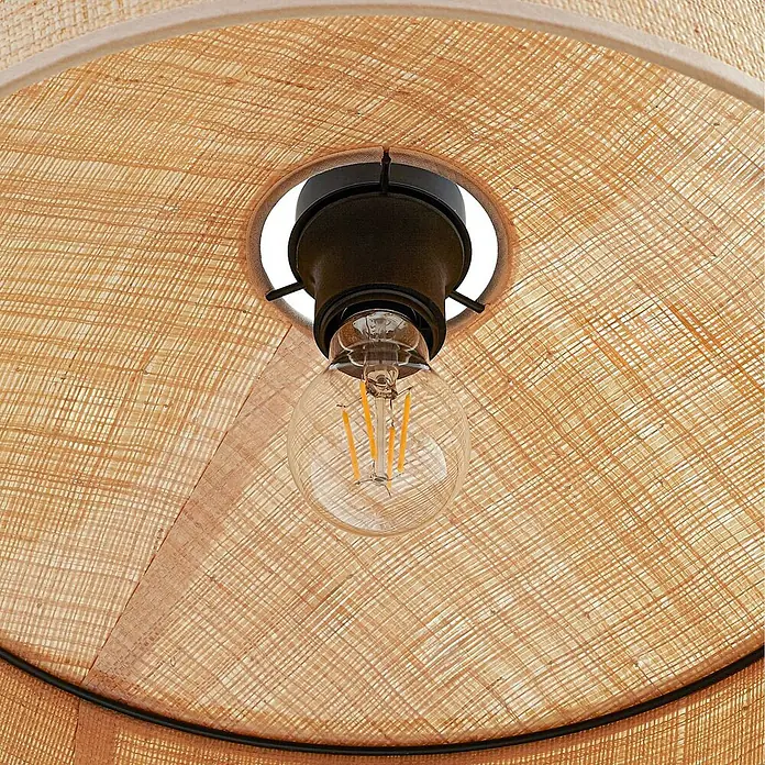 Lindby Pendelleuchte Haldor - L x B x H: 40 x 40 x 13,5 cm, creme / amber, beige, E27 - Blick ins Innere eines Lampenschirms aus naturfarbenem Flechtmaterial mit dunkler Fassung und LED-Filamentlampe.
