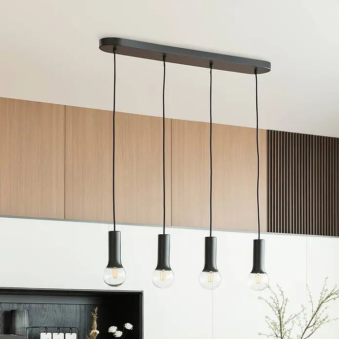 Lindby Pendelleuchte Fipas - Schwarz, E27 - Schwarze Mehrfach-Pendelleuchte mit rechteckiger Deckenplatte und vier zylindrischen Schirmen, die jeweils eine klare LED-Birne halten, in modernem Interieur.