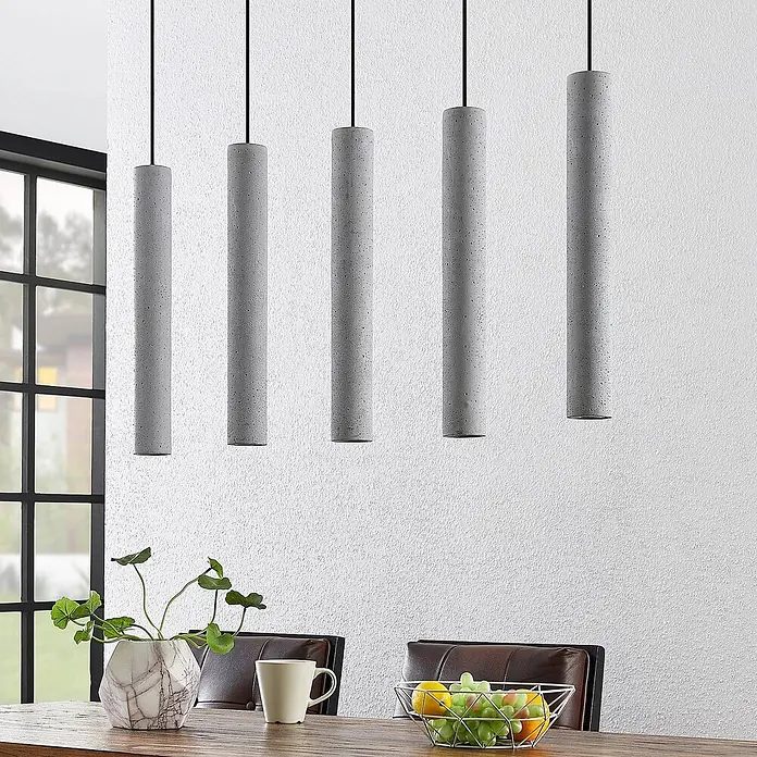 Lindby Pendelleuchte Concretto - alu / grau / zink, grau, GU10 - Fünf graue Beton-Pendelleuchten hängen über einem Tisch.