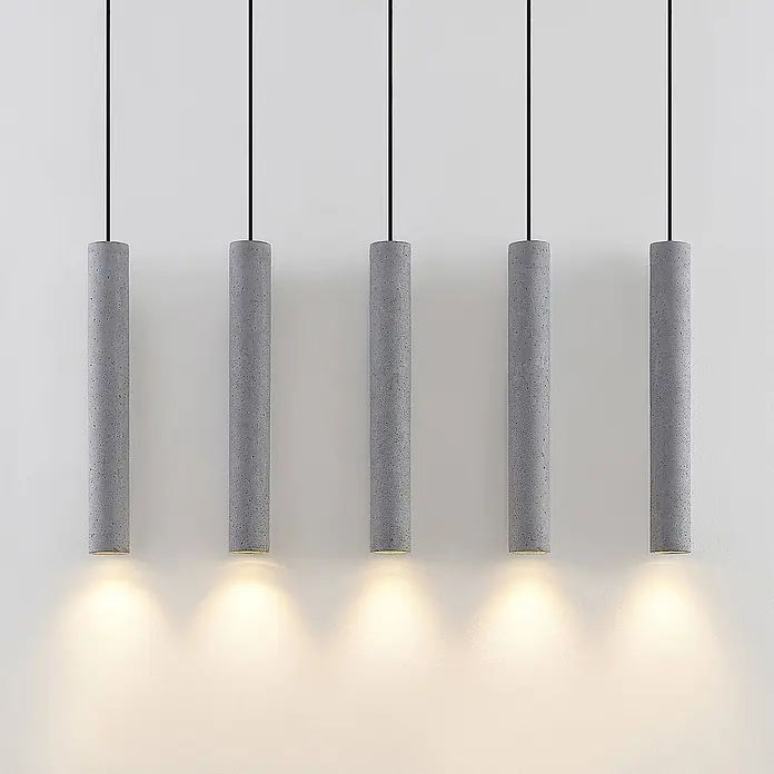 Lindby Pendelleuchte Concretto - alu / grau / zink, grau, GU10 - Fünf graue Beton-Pendelleuchten hängen und strahlen warmes Licht nach unten ab.
