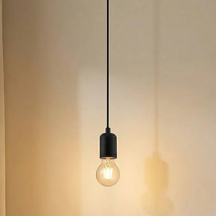 Lindby Pendelleuchte Hattie - L x B x H: 4,7 x 4,7 x 7 cm, schwarz, Schwarz, E27 - Schwarze Pendelleuchte mit klarer Glühbirne, beleuchtet eine hellfarbene Wand.