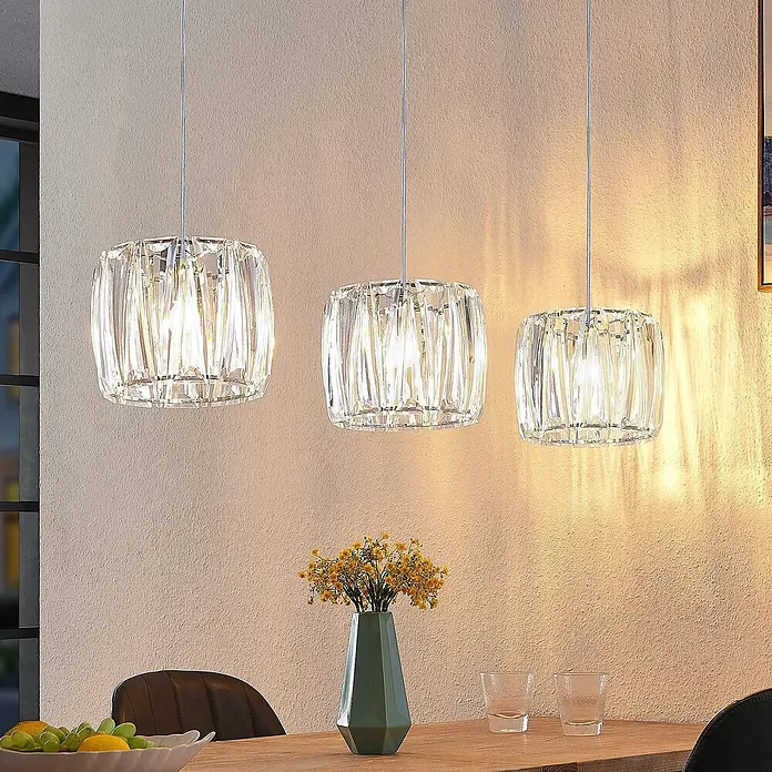 Lindby Pendelleuchte Sofia - L x B x H: 107 x 23 x 20 cm, klar / transparent, transparent, chrom, E14 - Drei klare, facettierte Kristall-Pendelleuchten über einem Esstisch.