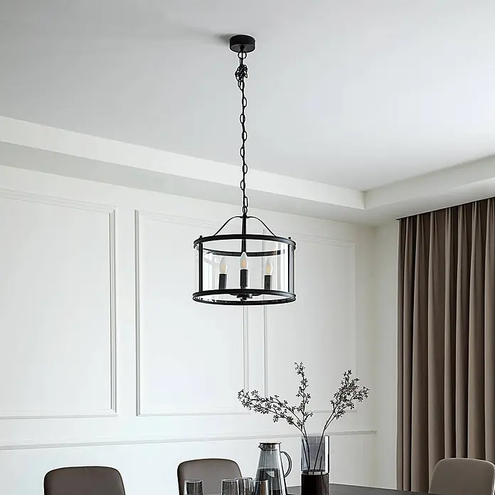 Lucande Pendelleuchte Eryk - L x B x H: 40,2 x 40,2 x 36,9 cm, schwarz, Schwarz, transparent, E14 - Schwarze Metall- und Klarglas-Trommel-Pendelleuchte mit drei Kerzenlampen über einem Esstisch.