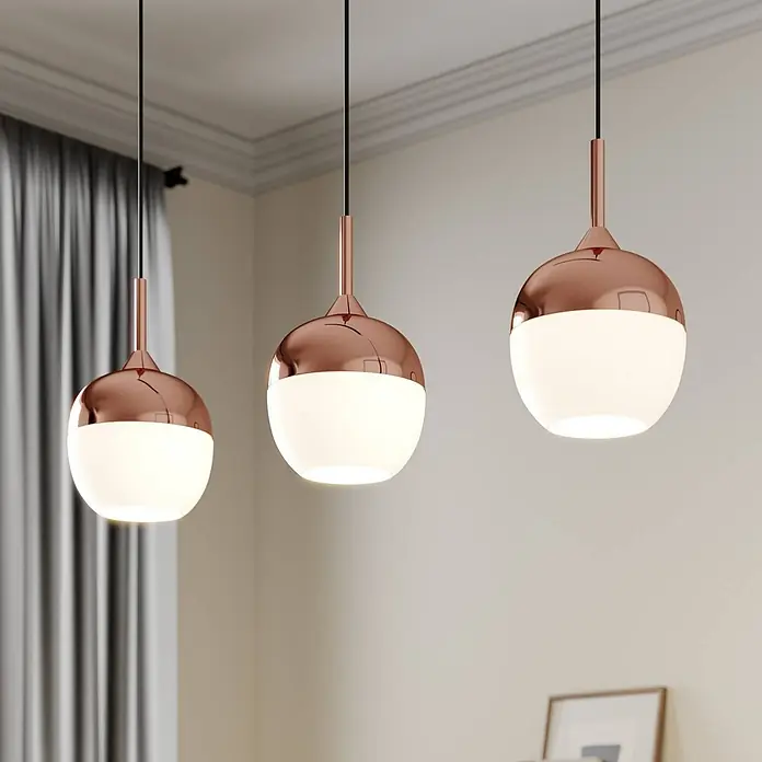 Lindby Pendelleuchte Rangina - kupfer, Kupfer, weiß, E27 - Drei Pendelleuchten mit roségoldfarbenen Metalloberteilen und beleuchteten weißen Glaskugeln hängen von der Decke.