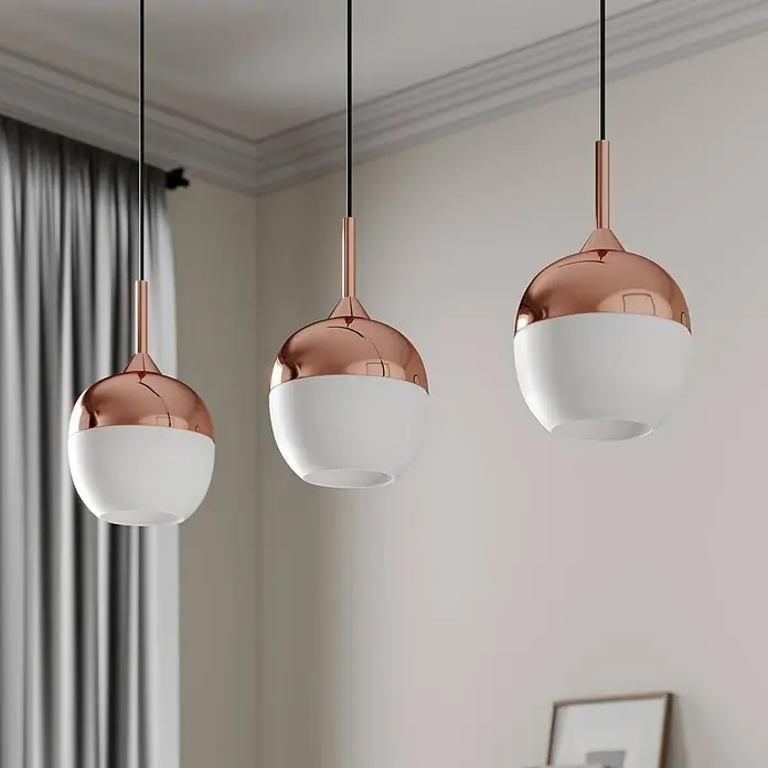 Lindby Pendelleuchte Rangina - kupfer, Kupfer, weiß, E27 - Drei moderne Pendelleuchten mit kupferfarbenen Oberteilen und weißen Glaskugelschirmen hängen von der Decke.