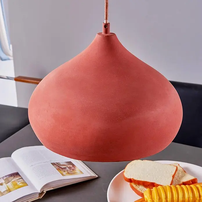 Lindby Pendelleuchte Fiona - L x B x H: 30 x 30 x 17 cm, terracotta, Terrakotta, E27 - Terrakotta-Pendelleuchte in Tropfenform über einem Tisch mit Buch und Essen.