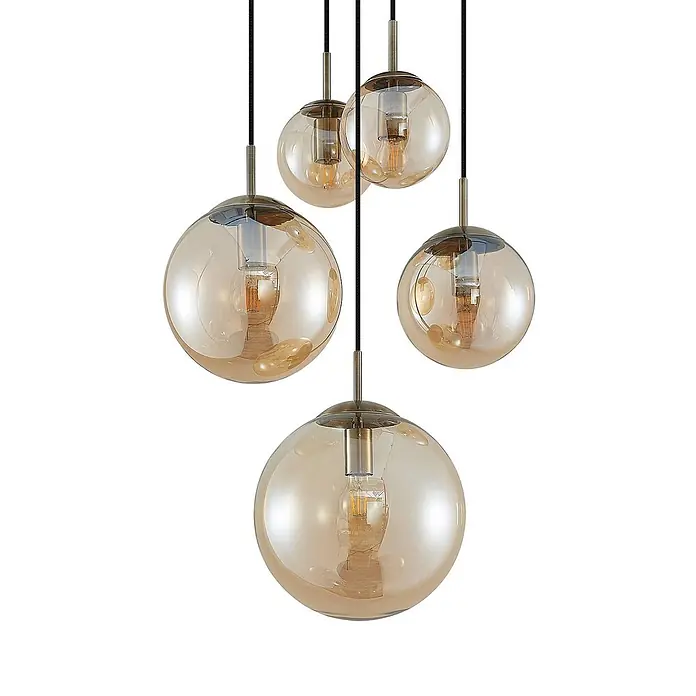 Lindby Pendelleuchte Teeja - L x B x H: 50 x 50 x 30 cm, creme / amber, amber, altmessing, E27 - Fünf bernsteinfarbene Glaskugel-Pendelleuchten mit Messingarmaturen und schwarzen Kabeln, hängen in unterschiedlichen Höhen.