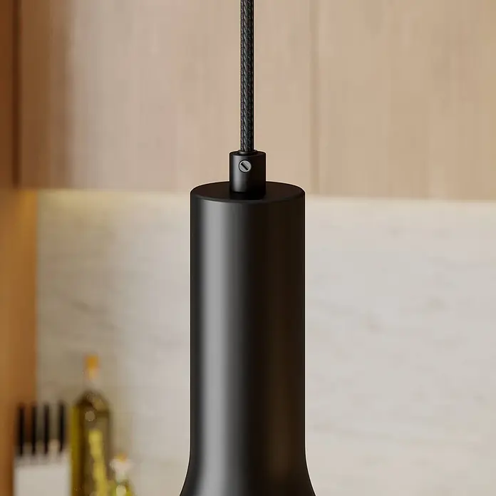 Arcchio Pendelleuchte Cosmina - L x B x H: 17,5 x 17,5 x 26 cm, schwarz, Schwarz, gold, E27 - Schwarze zylindrische Pendelleuchte mit geflochtenem Kabel, in einer modernen Küche hängend.
