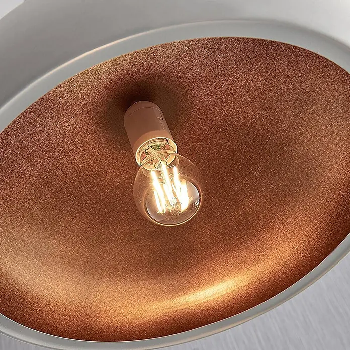 Lindby Pendelleuchte Gerwina - L x B x H: 40 x 40 x 15 cm, weiß / opal, weiß, gold, E27 - Nahaufnahme einer Leuchte mit texturierter kupferbrauner Innenseite, sichtbarer LED-Glühfadenbirne und hellgrauem Rand.