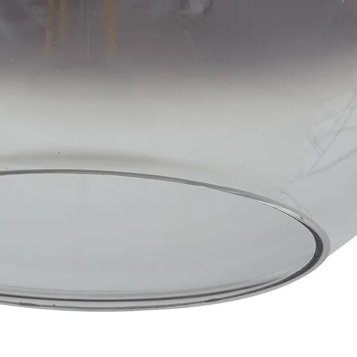 Lucande Pendelleuchte Brillar - L x B x H: 128 x 30 x 26,5 cm, alu / grau / zink, rauchgrau, zementgrau, E27 - Nahaufnahme eines durchscheinenden, rauchgrauen Glasschirms mit gebogenem Rand, der innere Elemente zeigt.