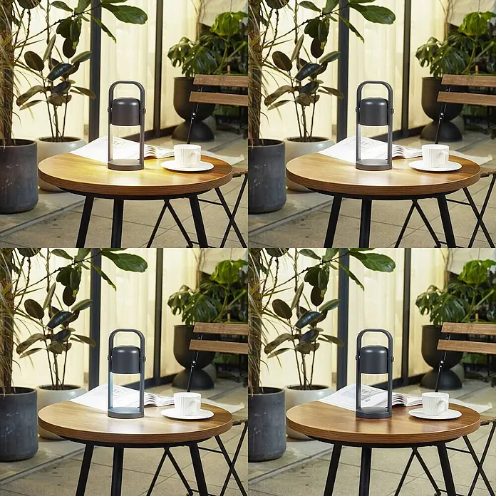 Lindby Tischleuchte Kalevi - schwarz, schwarz - Dunkelgraue tragbare Lampe auf einem Holztisch mit Tasse und Buch, in einer Außenumgebung.
