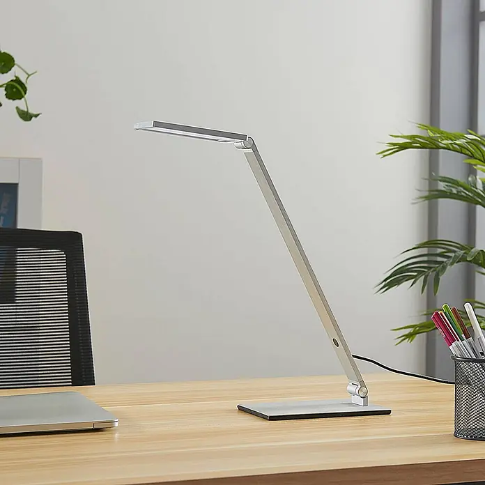 Lucande Tischleuchte Resi - L x B x H: 18 x 12 x 41 cm, alu / grau / zink, alu / grau / zink - Silberne LED-Schreibtischlampe mit verstellbarem Arm auf einem Holzschreibtisch im Büro.