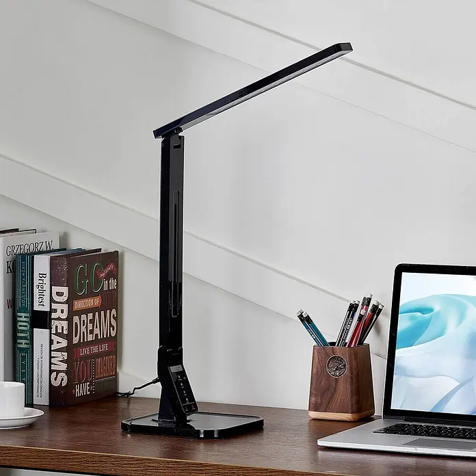 Lindby Tischleuchte Eleni - L x B x H: 18 x 17,2 x 45 cm, schwarz, schwarz - Schwarze LED-Schreibtischlampe auf einem Holztisch, beleuchtet Bücher, Stifthalter und Laptop.