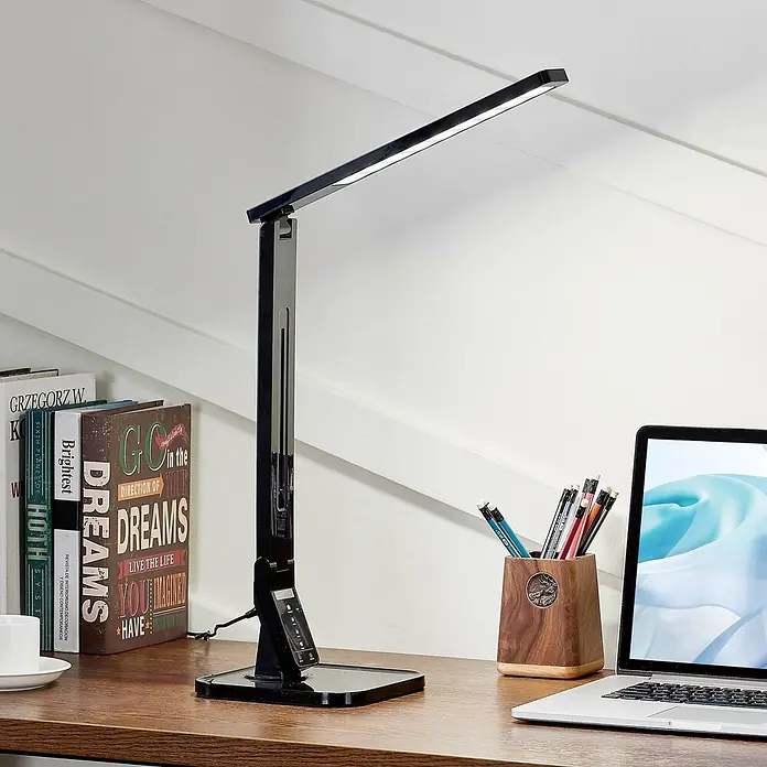 Lindby Tischleuchte Eleni - L x B x H: 18 x 17,2 x 45 cm, schwarz, schwarz - Elegante schwarze LED-Schreibtischlampe mit verstellbarem Arm und Touch-Bedienfeld, beleuchtet einen Holzschreibtisch.