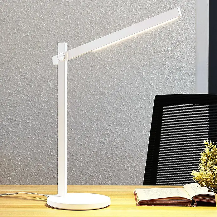 Lindby Tischleuchte Loretta - L x B x H: 40,8 x 17 x 43 cm, weiß / opal, weiß / opal - Weiße moderne LED-Schreibtischlampe mit verstellbarem Arm, leuchtend, auf einem Holzschreibtisch neben einem Buch.