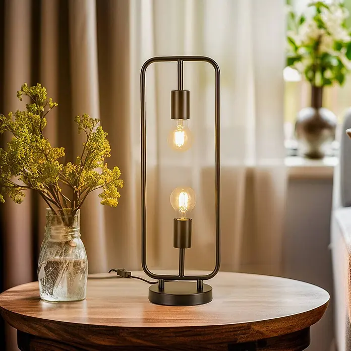 Lucande Tischleuchte Tornike - L x B x H: 15 x 18,5 x 56 cm, schwarz, E27 - Schwarze Metall-Tischlampe mit zwei sichtbaren Edison-Glühbirnen auf einem Holztisch, neben einer Vase mit gelben Blumen.