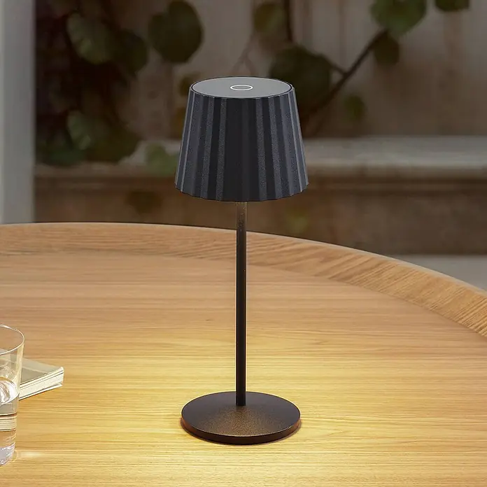 Lindby Tischleuchte Esali - L x B x H: 11 x 11 x 28,5 cm, schwarz, schwarz - Schwarze, tragbare Tischleuchte mit geripptem Schirm, beleuchtet einen hellen Holztisch.