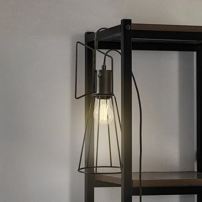 Lindby Tischleuchte Tharion - L x B x H: 15,4 x 15,4 x 42,6 cm, schwarz, E27 - Industrielle Käfiglampe aus dunklem Metall mit LED-Glühbirne, an Regal befestigt und beleuchtet.