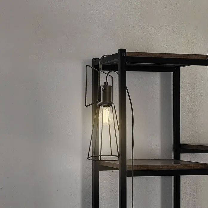 Lindby Tischleuchte Tharion - L x B x H: 15,4 x 15,4 x 42,6 cm, schwarz, E27 - Industrielle Käfigleuchte mit Edison-Birne und Schalter, an einem Regal aus dunklem Metall und Holz befestigt.