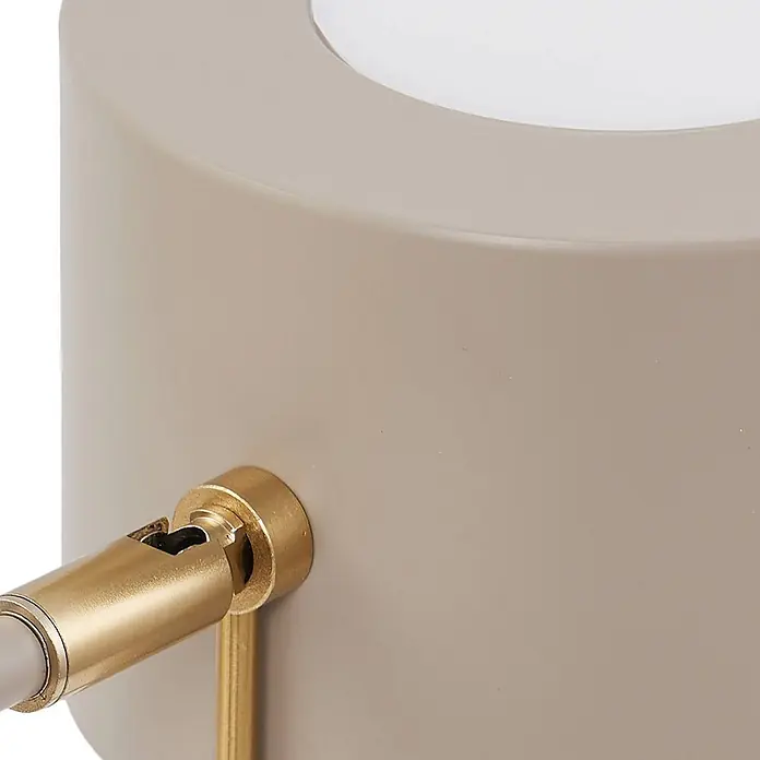 Lindby Tischleuchte Kaida - L x B x H: 30 x 15 x 43,5 cm, braun / rost, braun / rost, E27 - Nahaufnahme einer taupefarbenen zylindrischen Leuchte mit verstellbarem Messingarm und weißer, durchscheinender Oberseite.