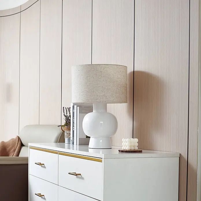 Lindby Tischleuchte Arved - L x B x H: 30 x 30 x 46 cm, weiß / opal, weiß / opal, E27 - Weiße Keramik-Tischlampe mit beigem Stoffschirm, auf einer weißen Kommode platziert.